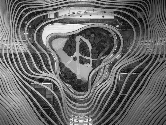 An aerial drone photography of a garden in the middle of curvy steel patterns - cool background